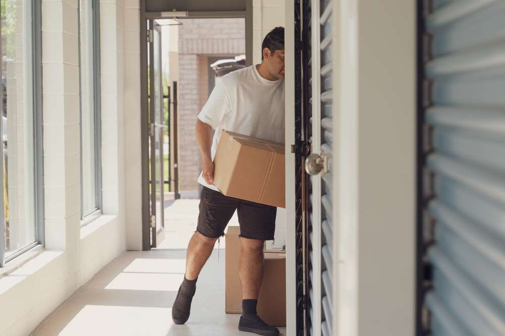 A,Unrecognizable,Man,Is,Carrying,A,Box,Into,A,Storage