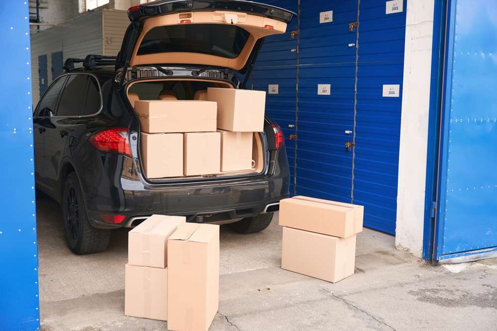 Car,With,Cardboard,Boxes,In,The,Trunk,Into,A,Warehouse