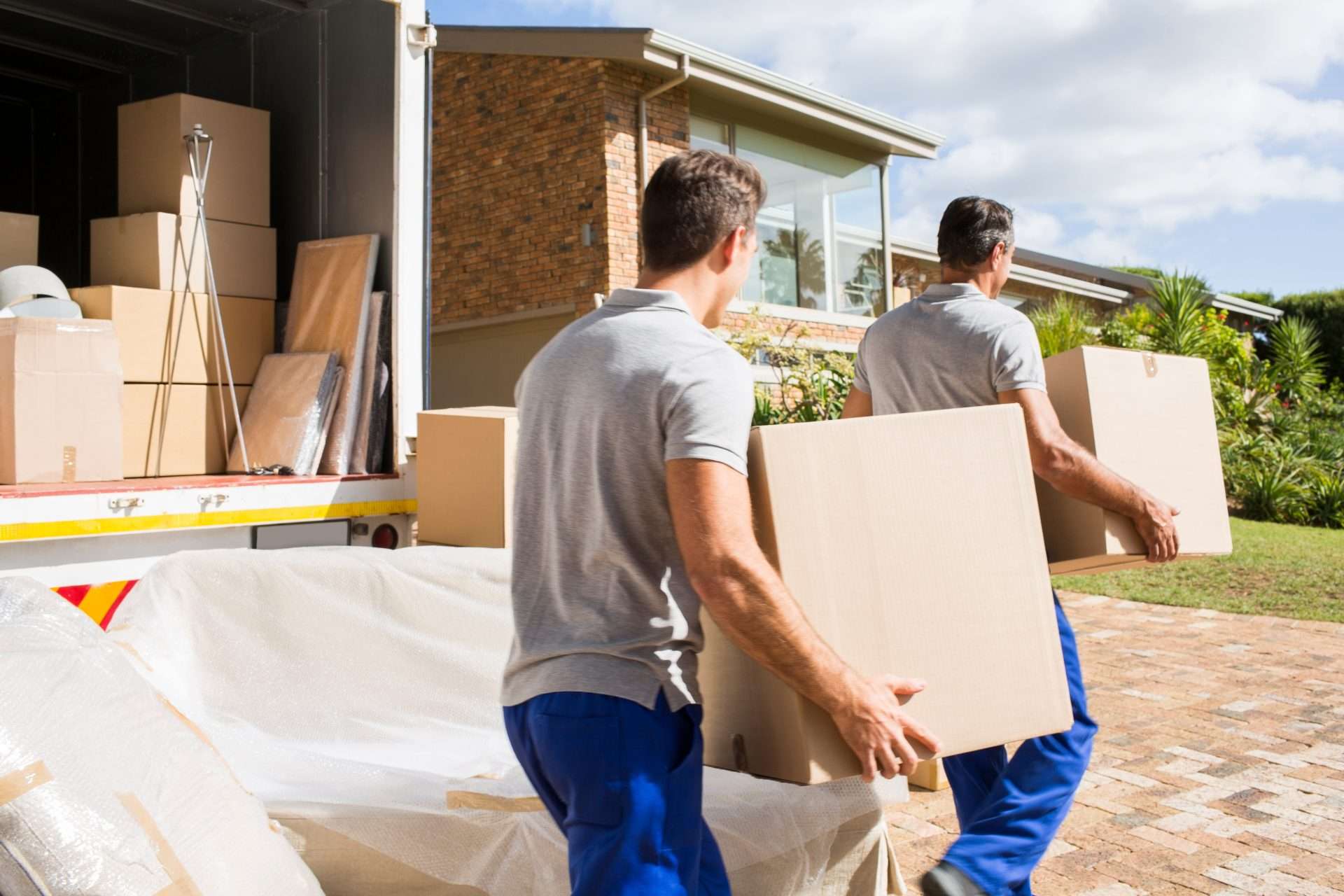 Jasper GA movers carrying boxes from the truck into a home
