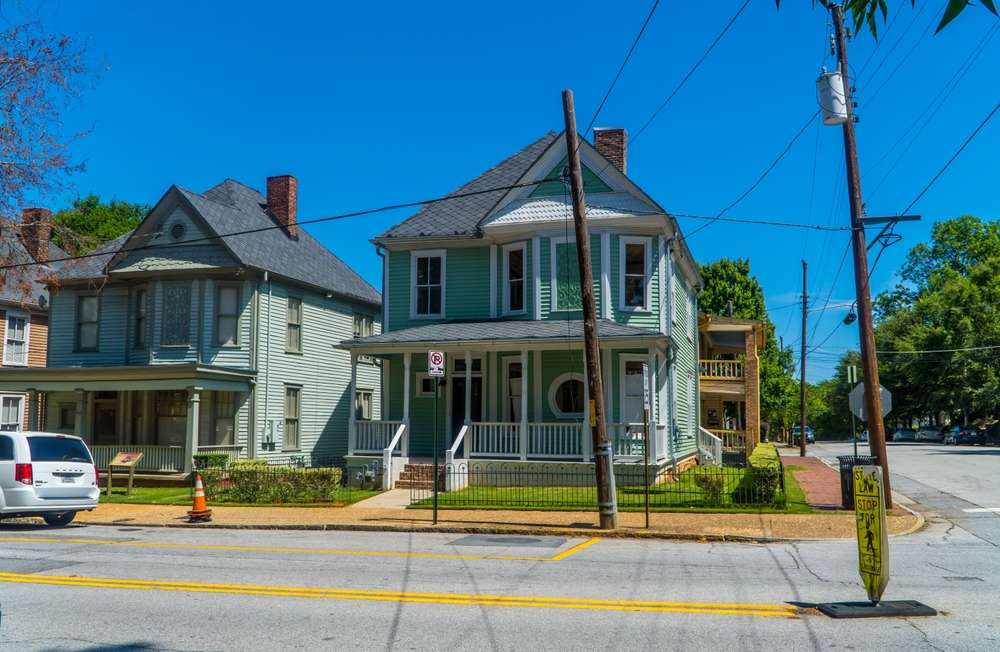 Neighborhood in auburn georgia with a mid 1900s home painted in green