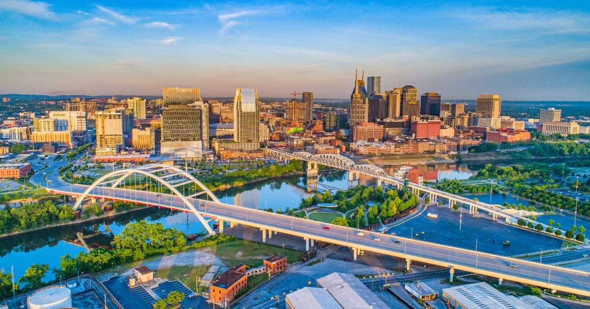 Aerial view of Downtown Nashville showing the Cumberland River, John Seigenthaler Pedestrian Bridge, and the Korean Veterans Memorial Bridge.