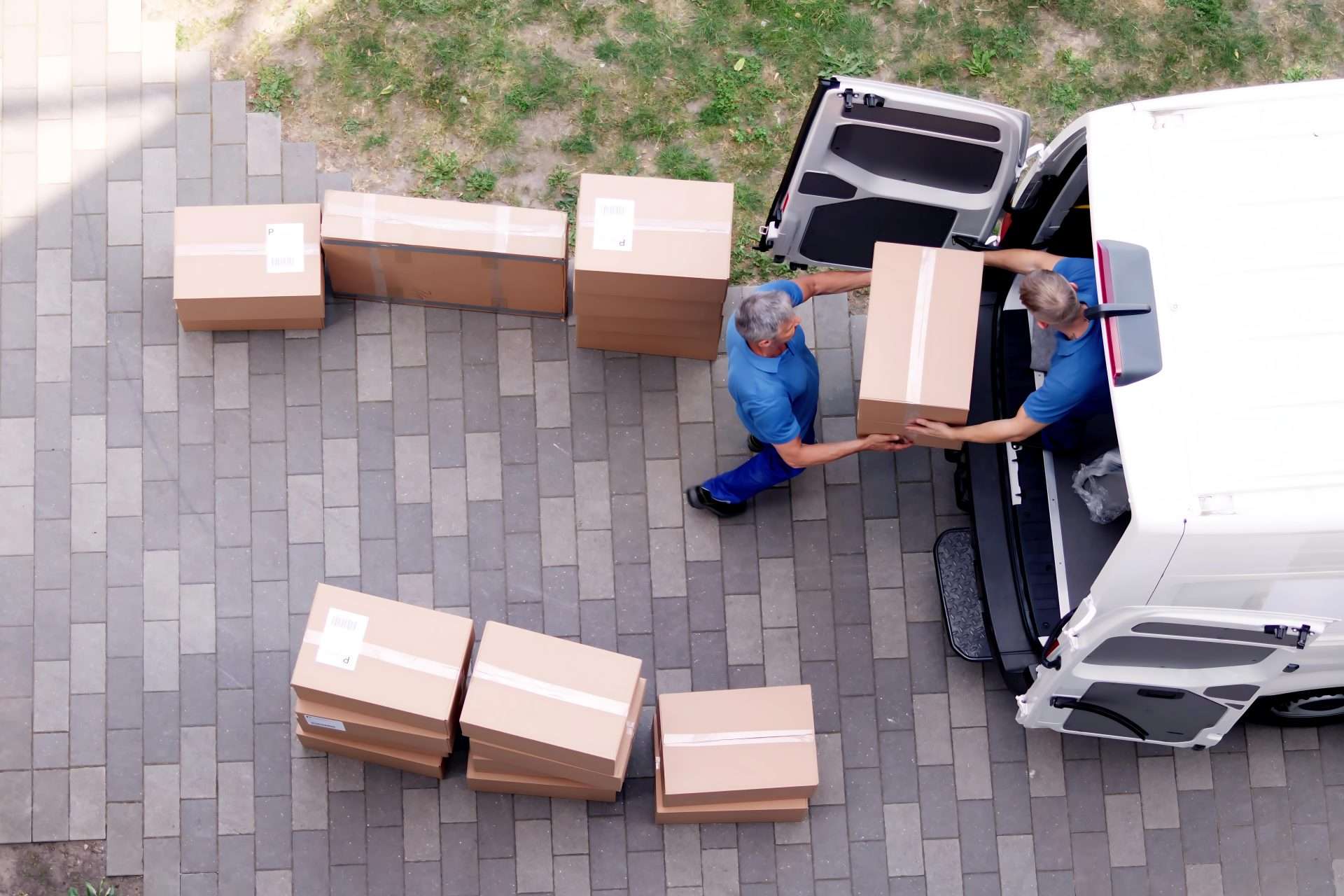Two movers loading boxes into a moving van.