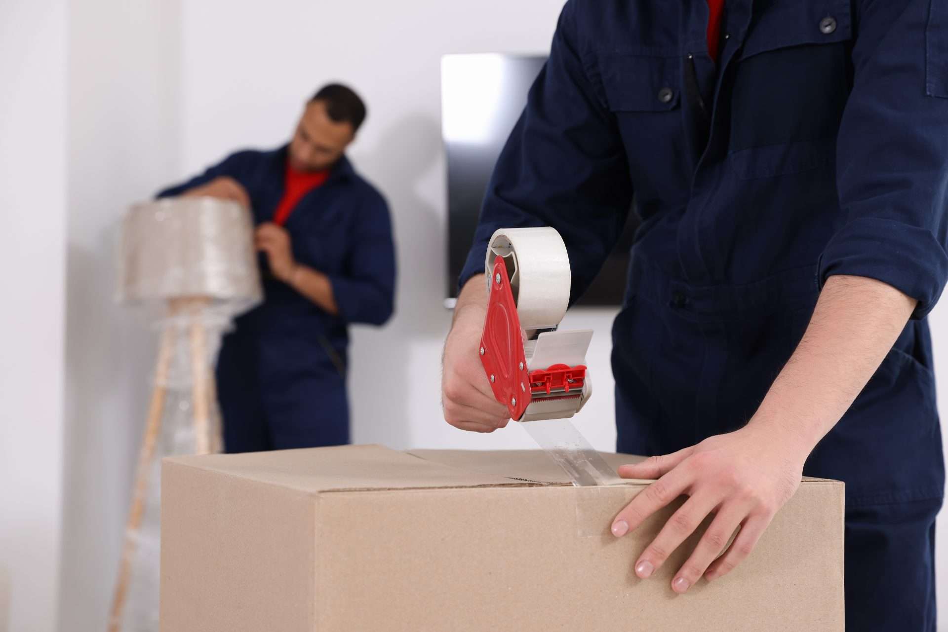 Heron Bay movers taping boxes in a customer’s home