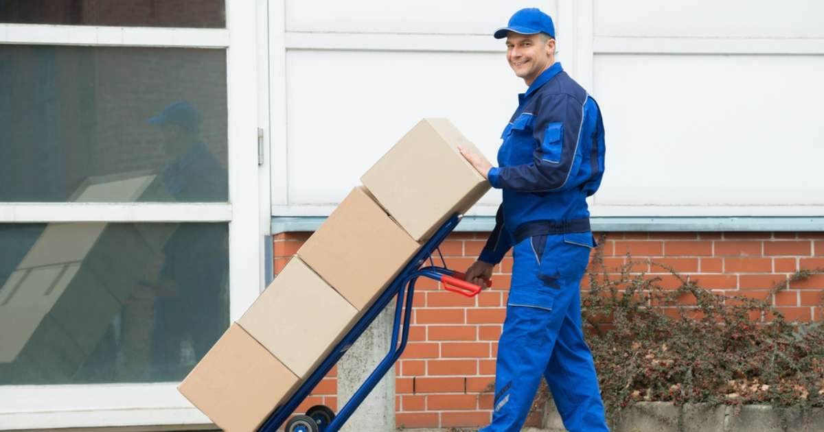 A mover from an Adairsville, GA moving company hauling boxes into a home 