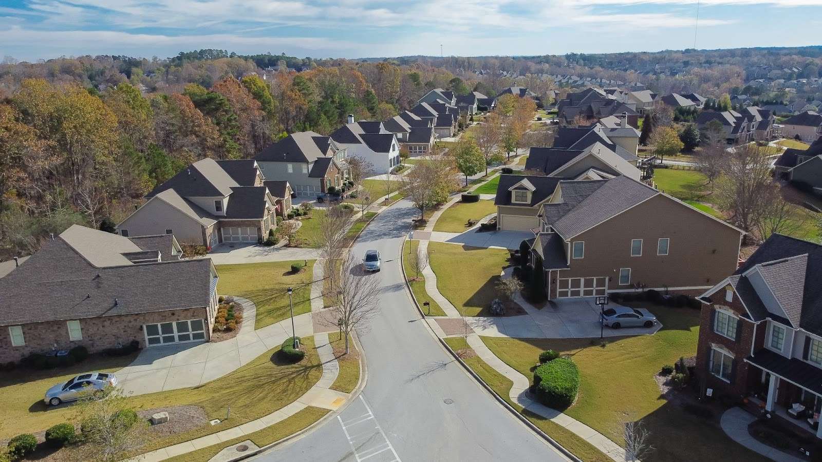 aerial view of a residential street in Flowery Branch, GA, with trees in the background.