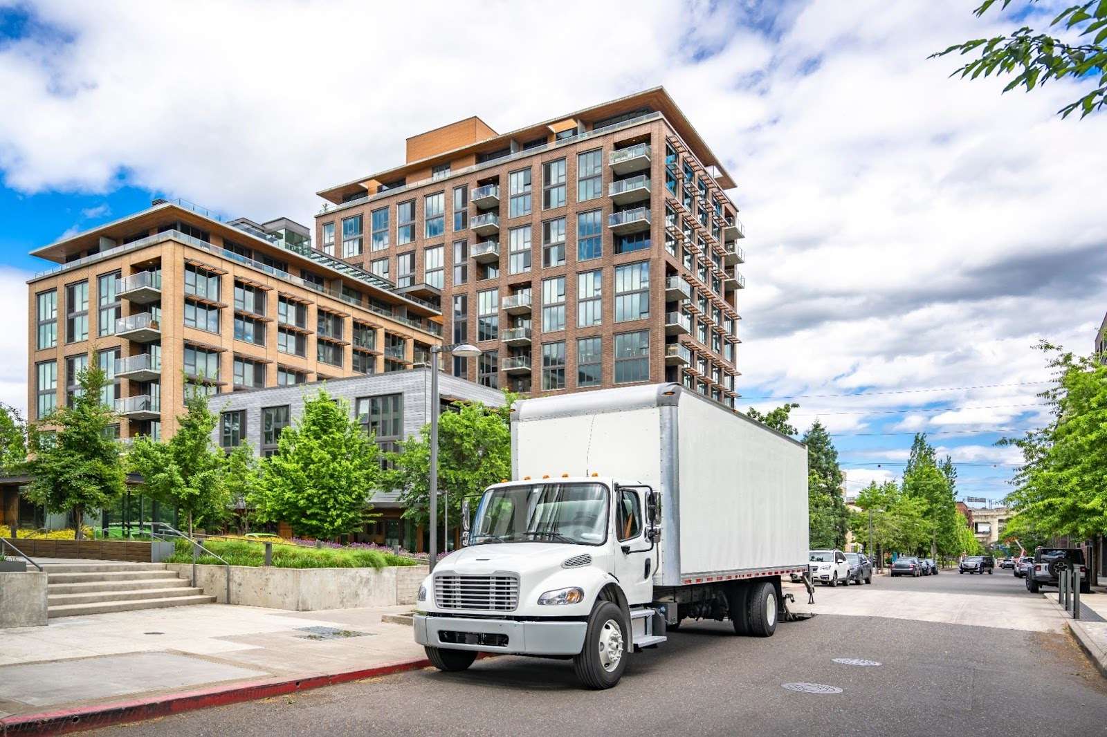 Moving truck parked outside of a high rise apartment building 