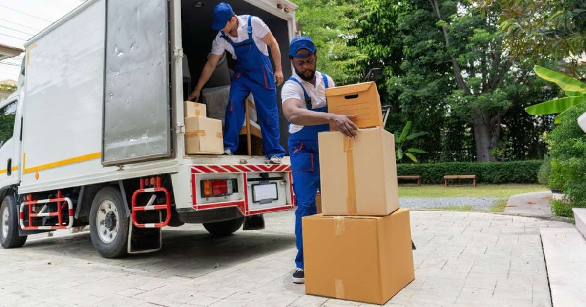 Two professionals from an Atlanta to Warner Robins moving company unloading boxes