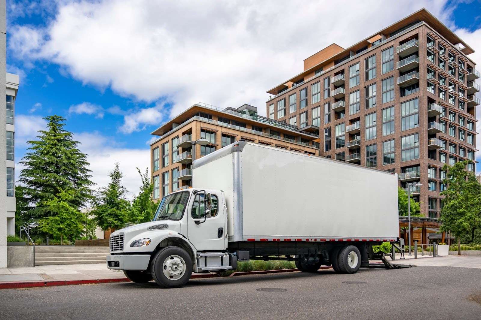 Moving truck parked in front of high-rise building